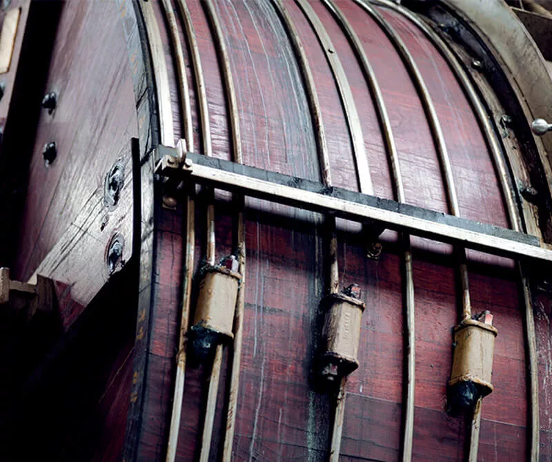 Détail d’un équipement industriel avec panneaux courbes en cuir et composants métalliques.