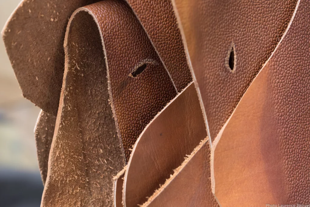 Stacked rawhides, grained texture, reddish-brown color, close-up detail.