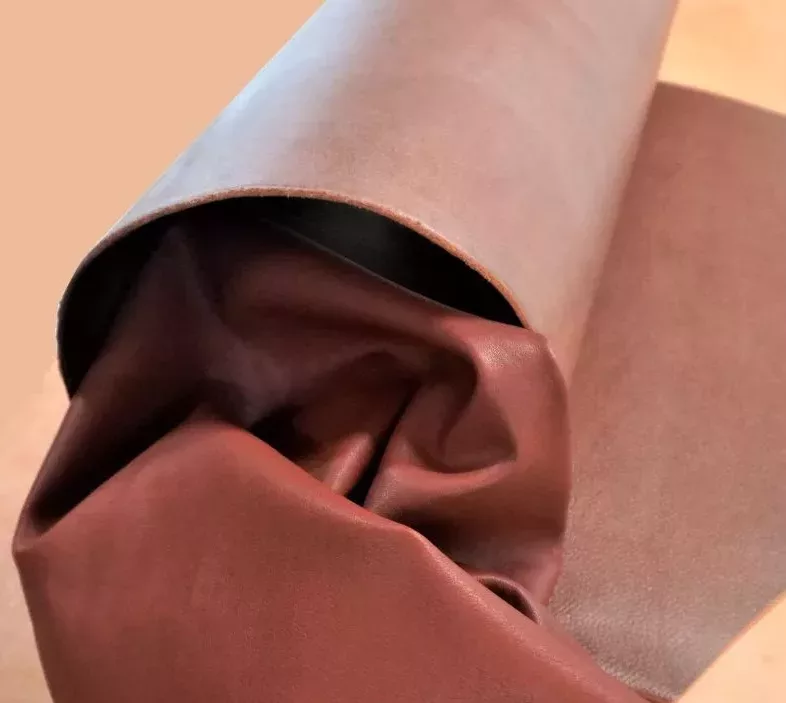 Cuir de veau rouge-brun enveloppé dans un cuir de bovin de couleur plus claire.