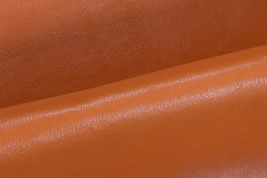 Texture of fine goat leather in a warm tan color.