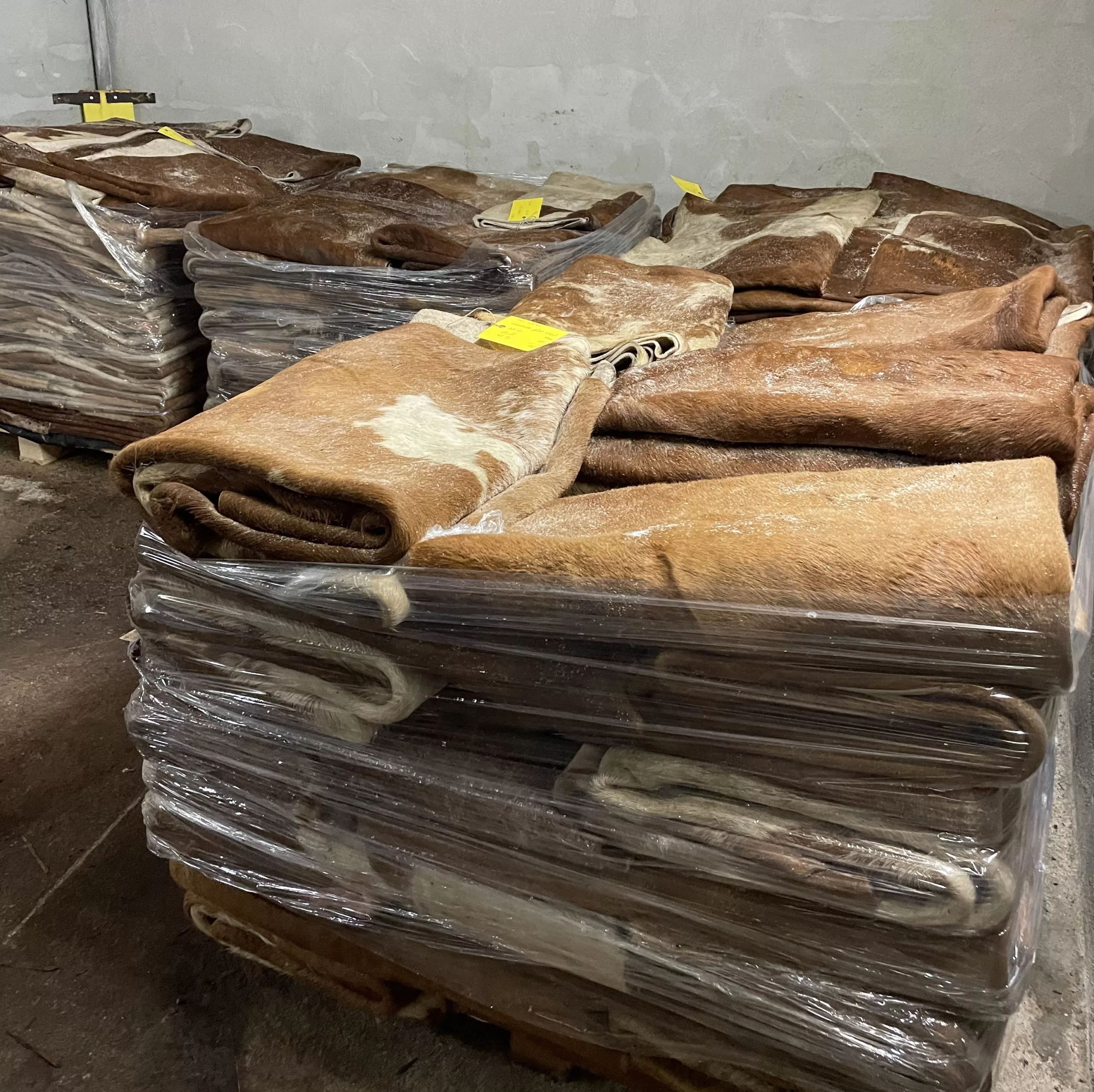 Raw bovine hides before processing, stacked on a pallet.