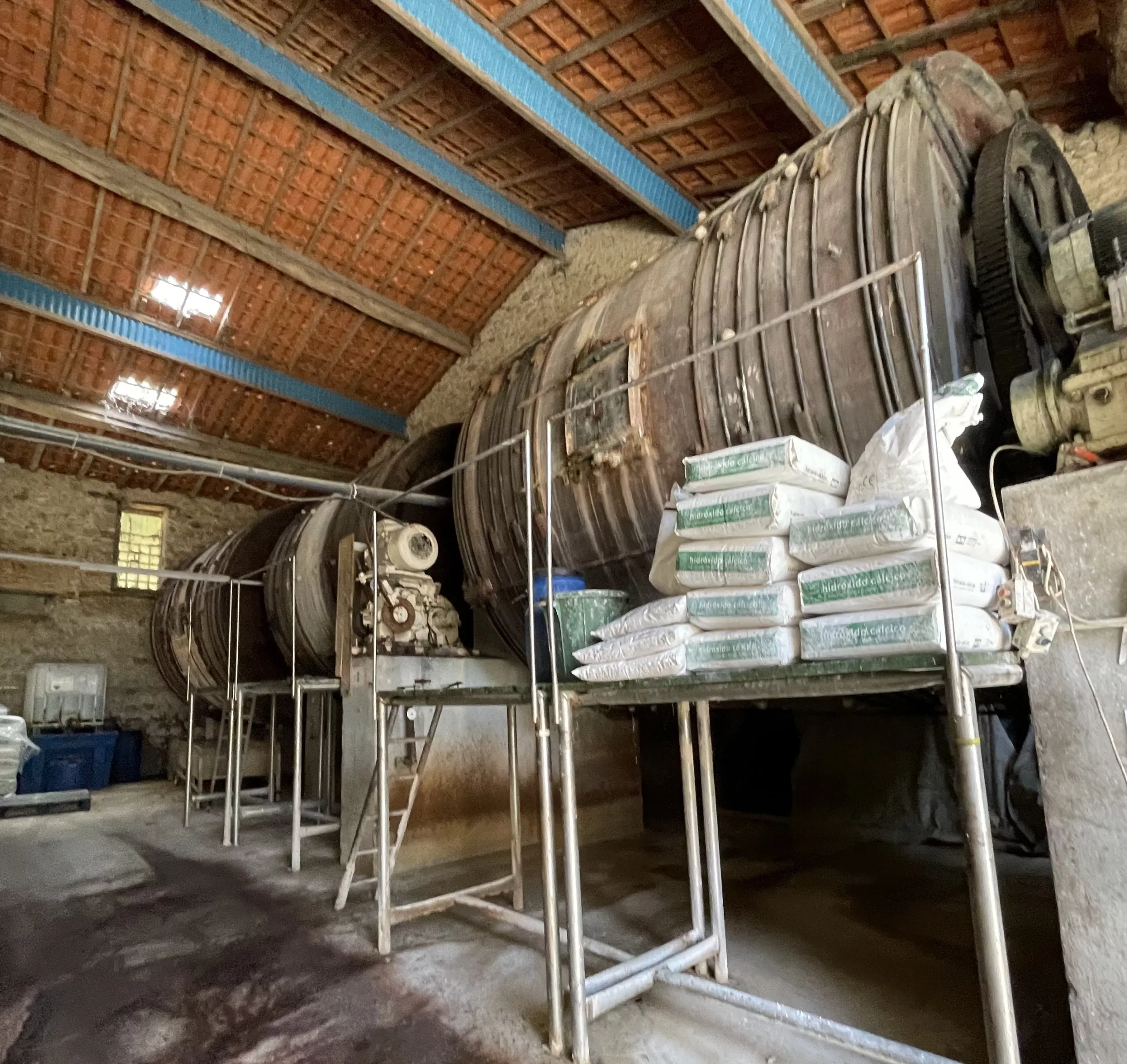 Grande tamburo rotante in acciaio utilizzato per la concia della pelle bovina in un edificio industriale.