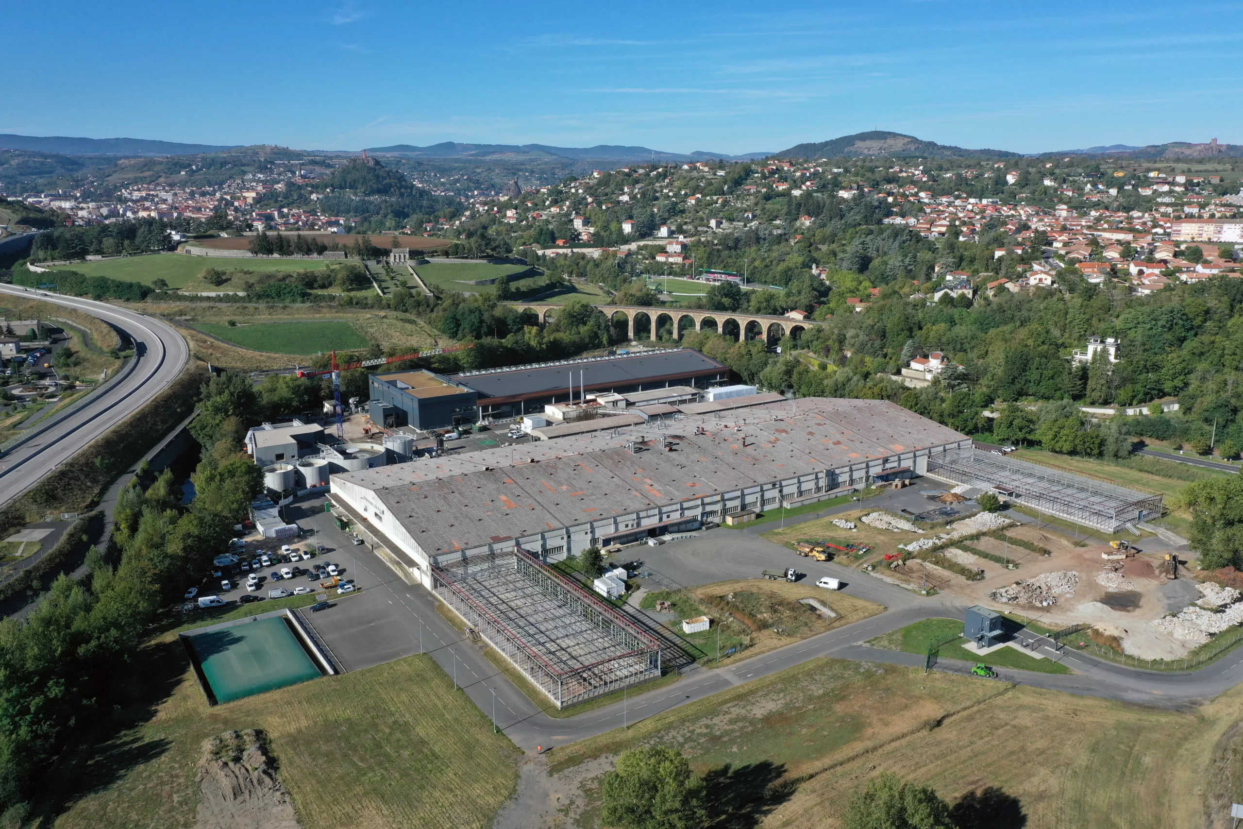 Vue aérienne des Tanneries du Puy, entourées de verdure et de collines.